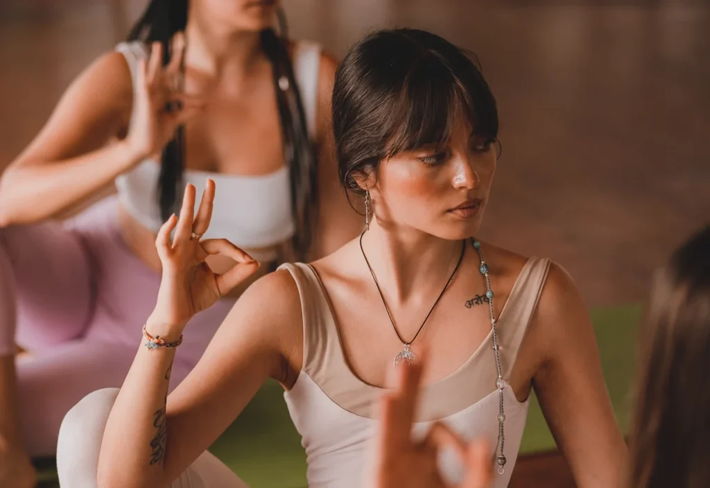 Yoga teacher training students practicing meditation and mudras during a yoga class in Thailand