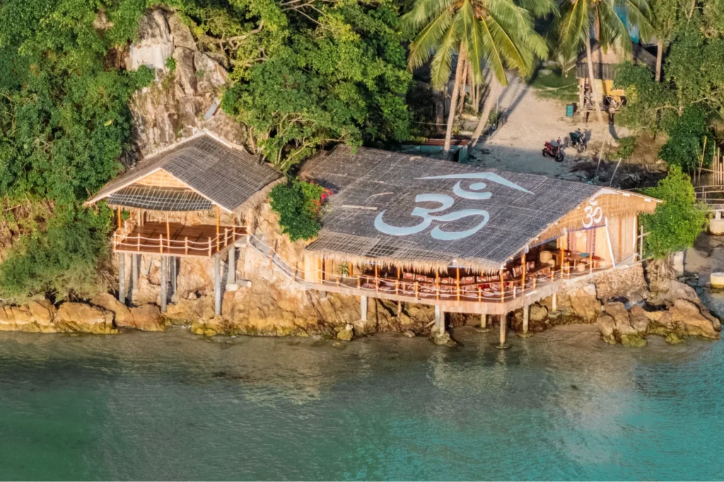 Aerial view of a beachfront yoga training venue on the tropical coast of Koh Phangan, Thailand