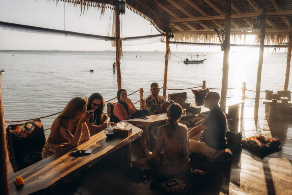 Yoga teacher training students relaxing together at a beachfront venue in Koh Phangan, Thailand