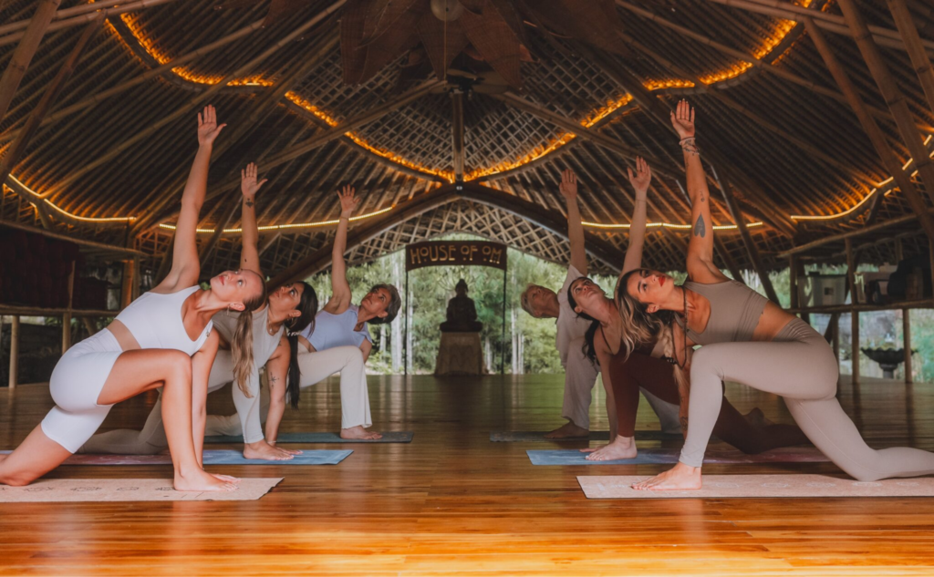 Students practicing yoga in an open-air shala during a Yoga Alliance-certified 200-hour Yoga Teacher Training at House of Om Bali.
