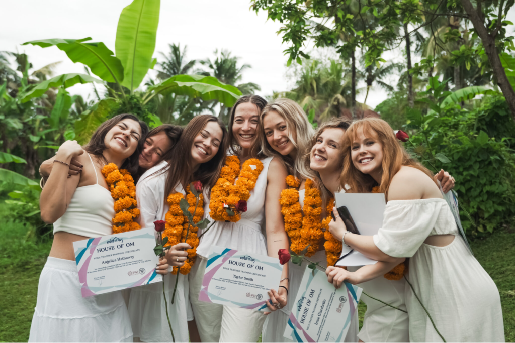 Graduates celebrating after completing their Yoga Alliance-certified 200-hour Yoga Teacher Training at House of Om Bali with certificates.