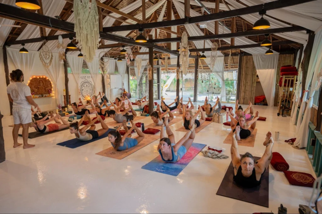 Yoga teacher leading students through an indoor yoga class at House of Om Thailand