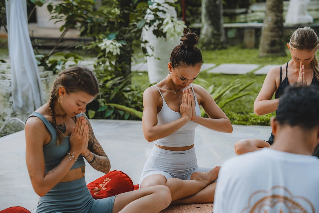 Beginner yoga students practicing seated prayer and meditation during yoga teacher training in Bali