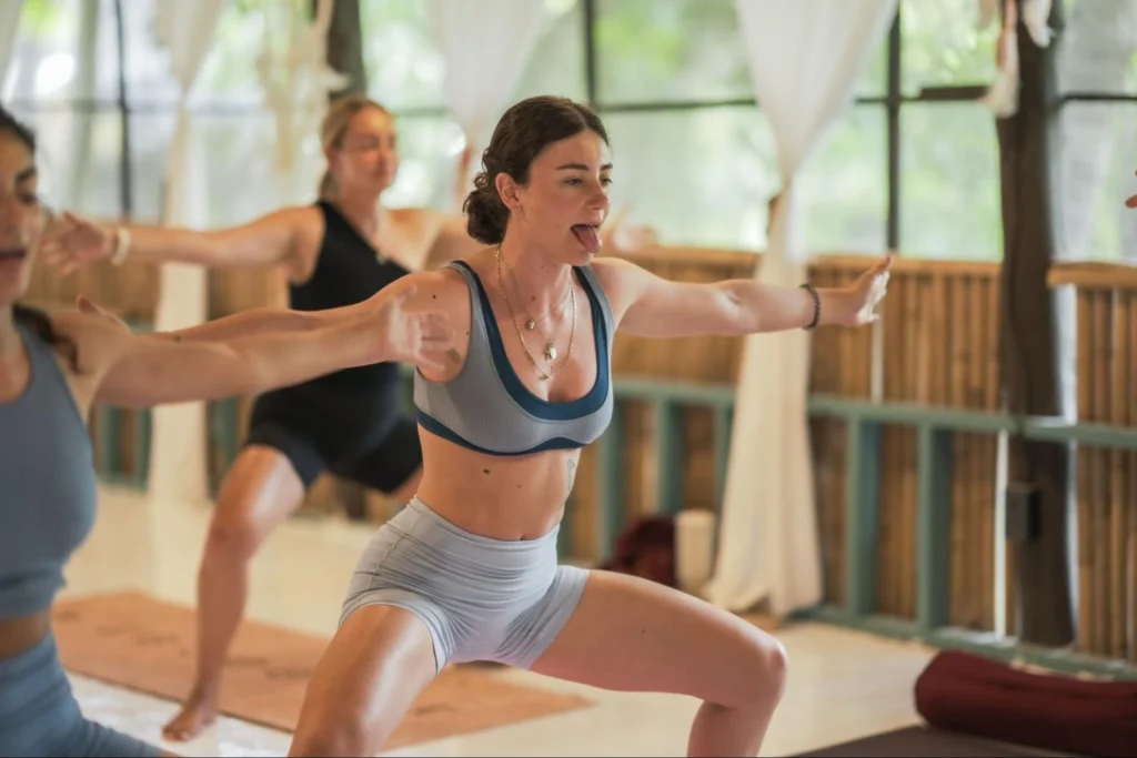 Yoga teacher training students practicing breathing exercises together in Thailand