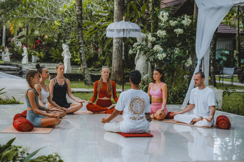 Yoga teacher leading a seated meditation circle during 200-hour yoga teacher training in Bali