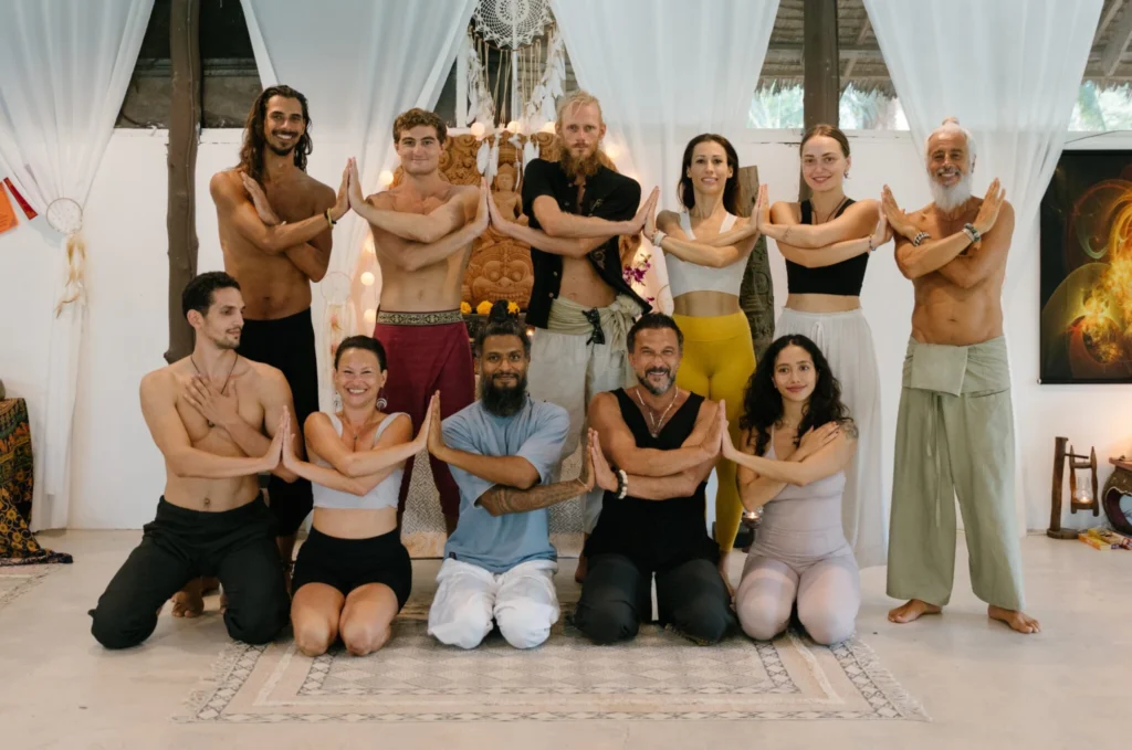 House of Om yoga teachers and students posing together inside the training studio