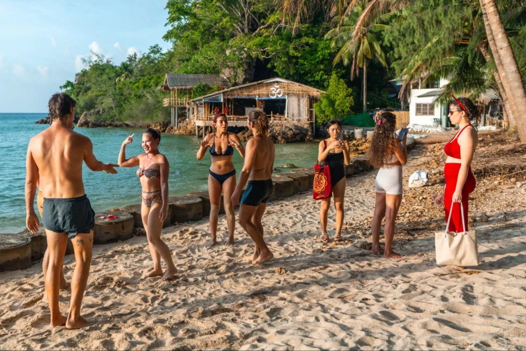 House of Om yoga students spending time together beside the beachfront training venue in Thailand