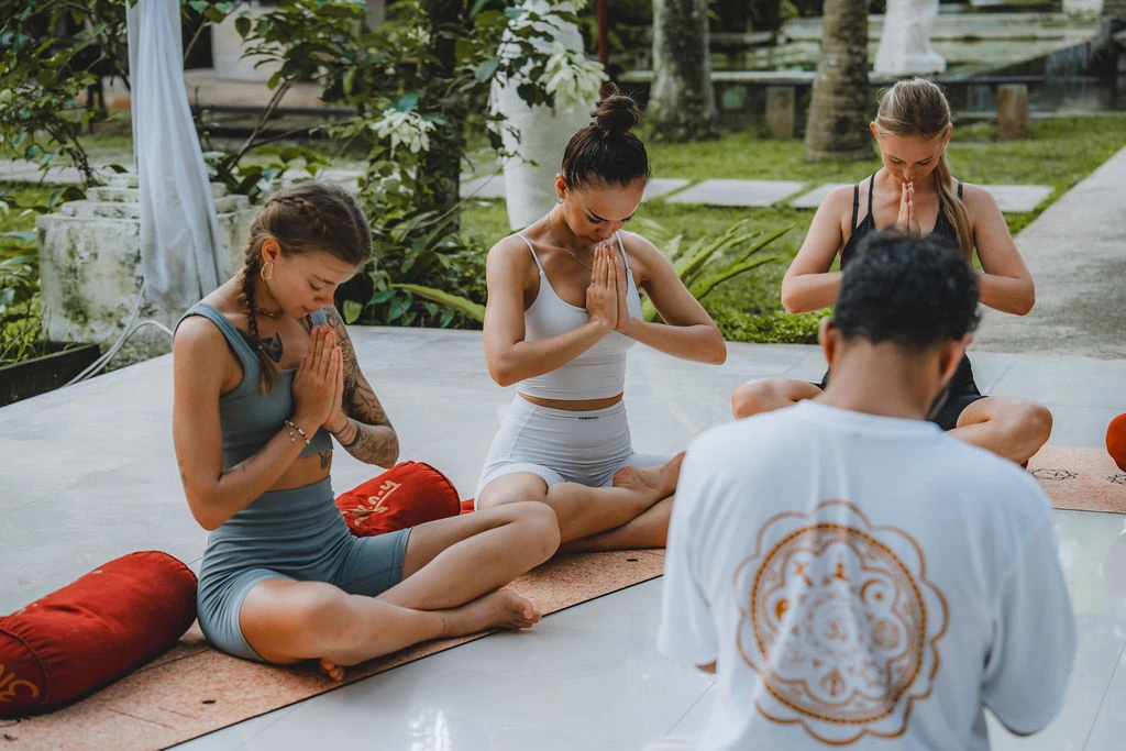 Yoga teacher guiding students through standing poses during a 200-hour training class