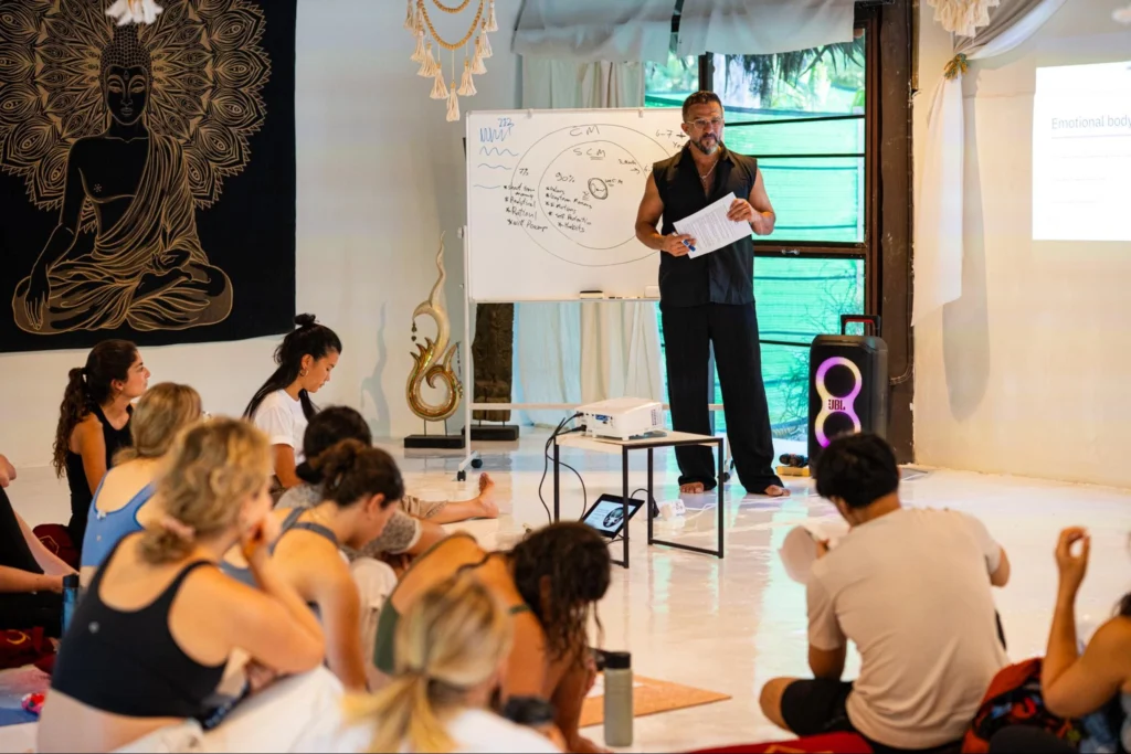 Instructor teaching yoga theory to students during House of Om teacher training in Thailand