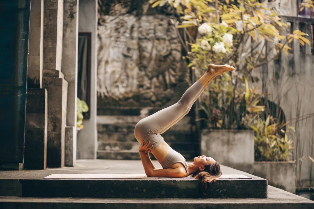 Yoga student practicing a supported inversion pose during yoga training in Bali