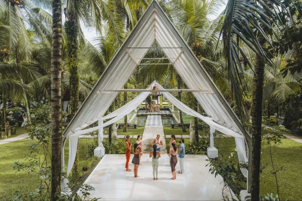 Tropical yoga training venue surrounded by palm trees at The Mansion Bali