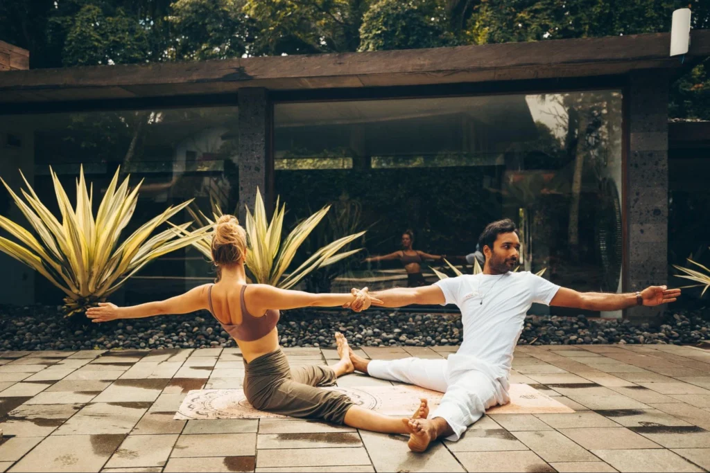 Yoga partners practicing a seated stretching exercise during House of Om teacher training in Bali