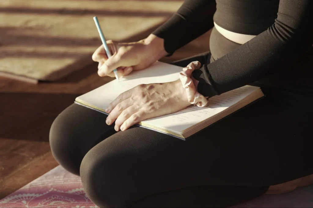 Student taking notes during a 200-hour yoga teacher training course