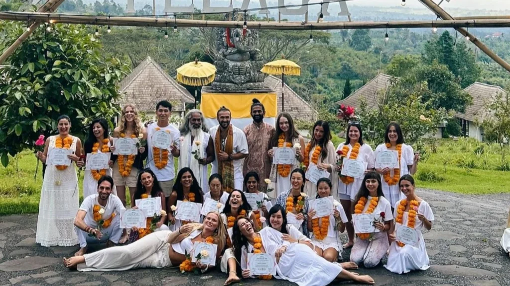 Yoga teacher training graduates holding certificates after completing their 200-hour training