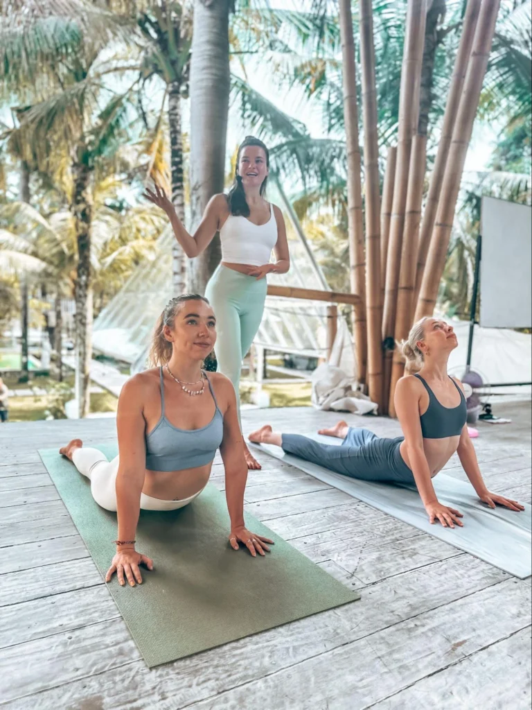 Yoga instructor guiding students through cobra pose during a practical training session