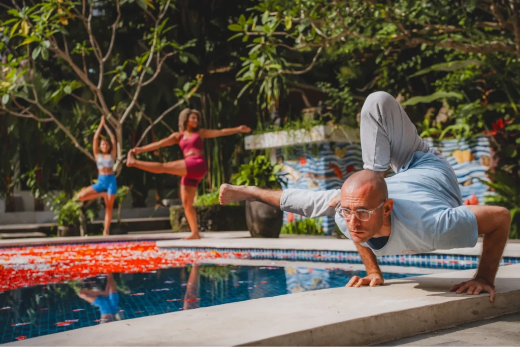 Woman practicing Pigeon Pose in an open-air tropical yoga studio
