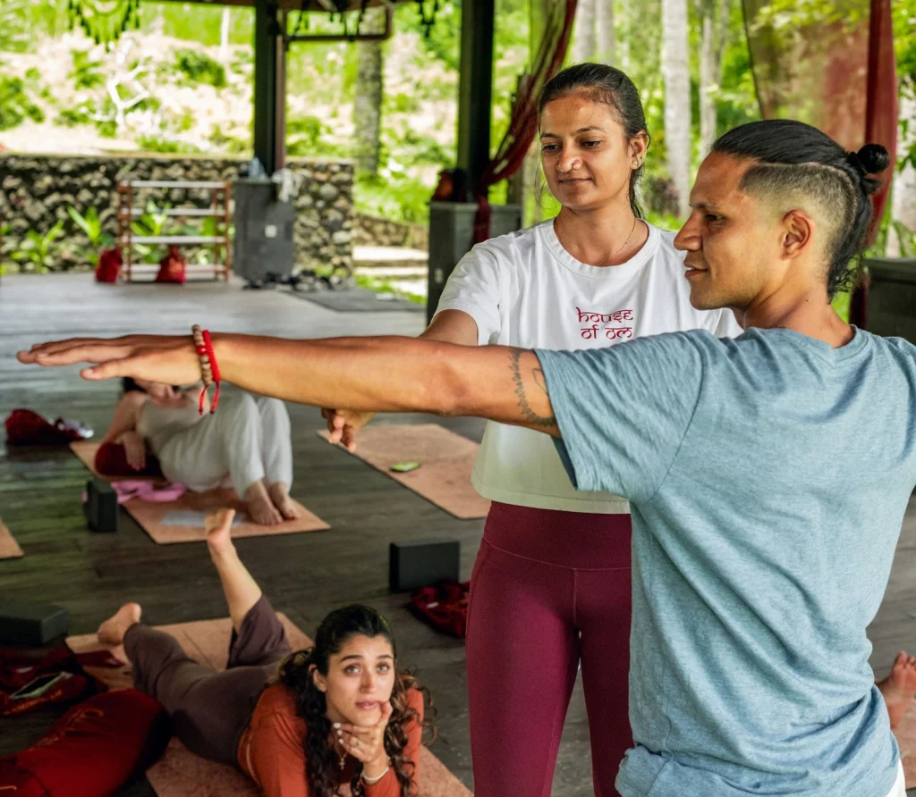 Yoga instructor guiding a student during 300-hour yoga teacher training in Bali