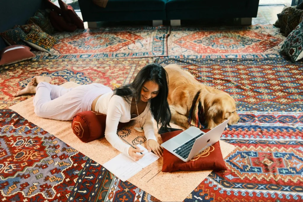 Online yoga teacher training student studying course material at home