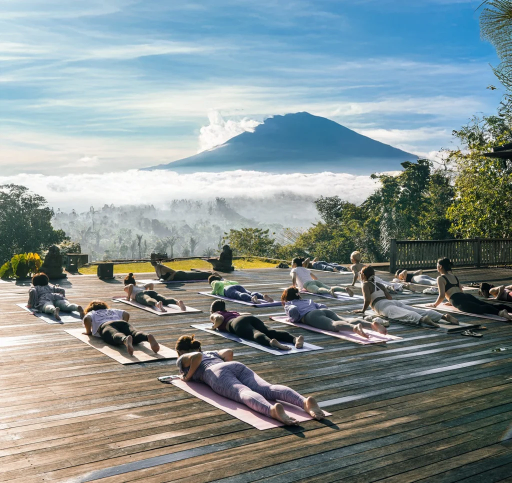 Outdoor yoga class overlooking a mountain during yoga teacher training in Bali