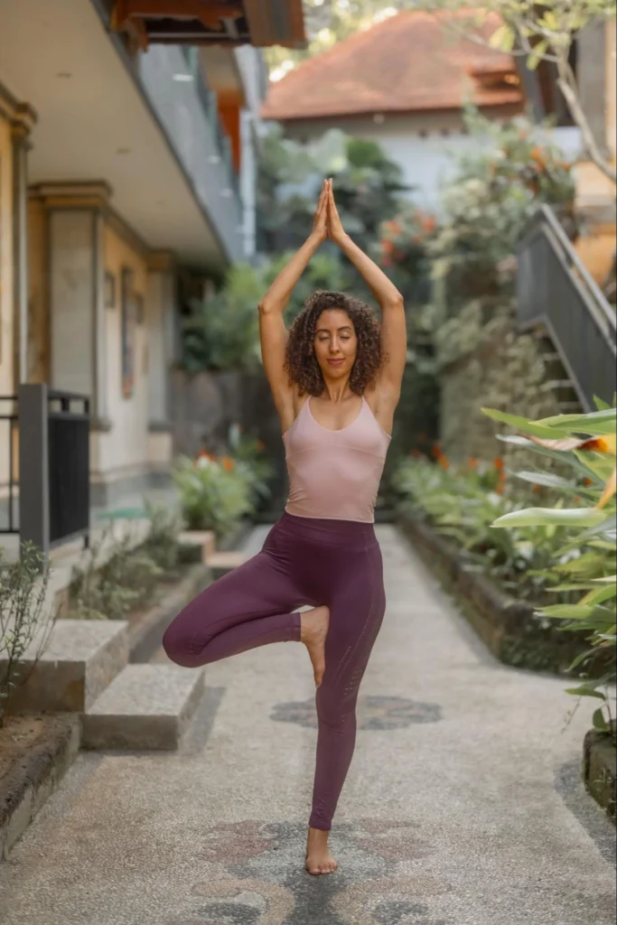 Yoga student practicing tree pose outdoors at Amertham yoga school in Bali