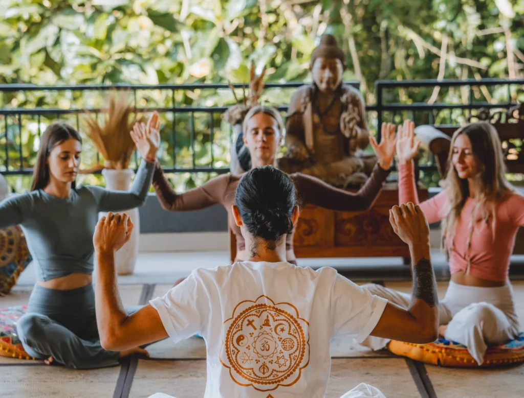 Yoga instructor assisting a student with alignment during yoga teacher training